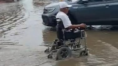 Captan a señor en silla de ruedas cruzando calle inundada a toda velocidad
