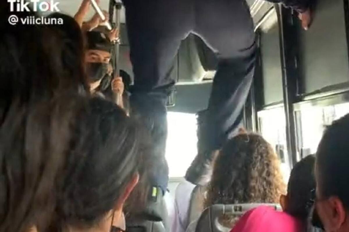 Joven camina sobre los asientos para poder bajar del transporte público en Los Mochis