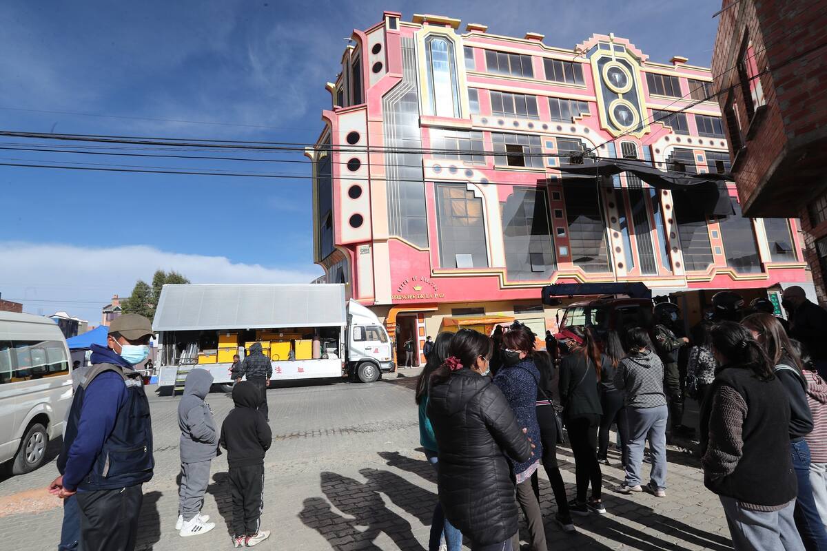 Varias personas pasan frente al set de grabación de la serie "La Reina del Sur", frente al edificio Príncipe de la Paz, hoy, en El Alto (Bolivia). EFE/ Martin Alipaz