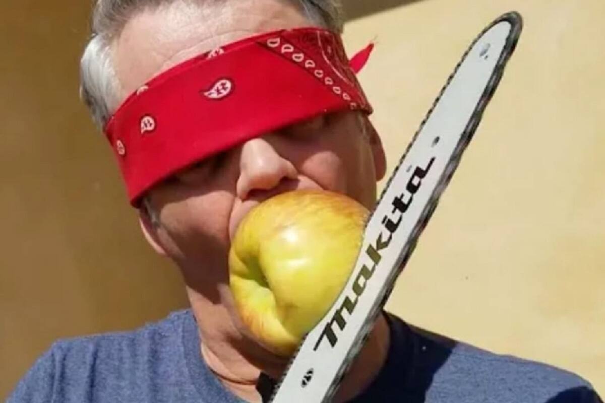 Hombre parte manzana en su boca con una motosierra y los ojos vendados