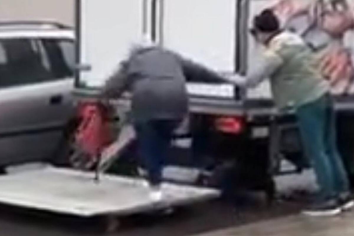 Hombres ayudan a señora de la tercera edad a llegar a su carro en estacionamiento inundado