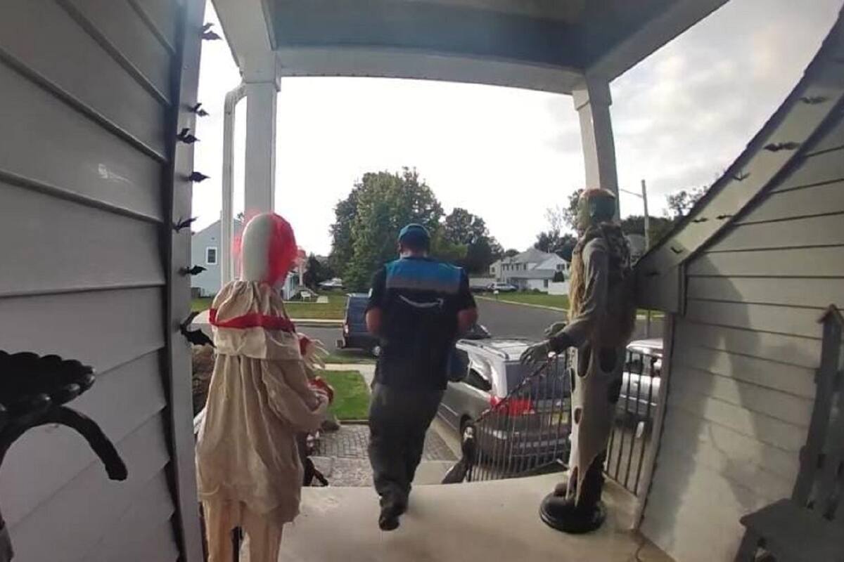 Repartidor sale corriendo del miedo con la decoración de Halloween de una casa