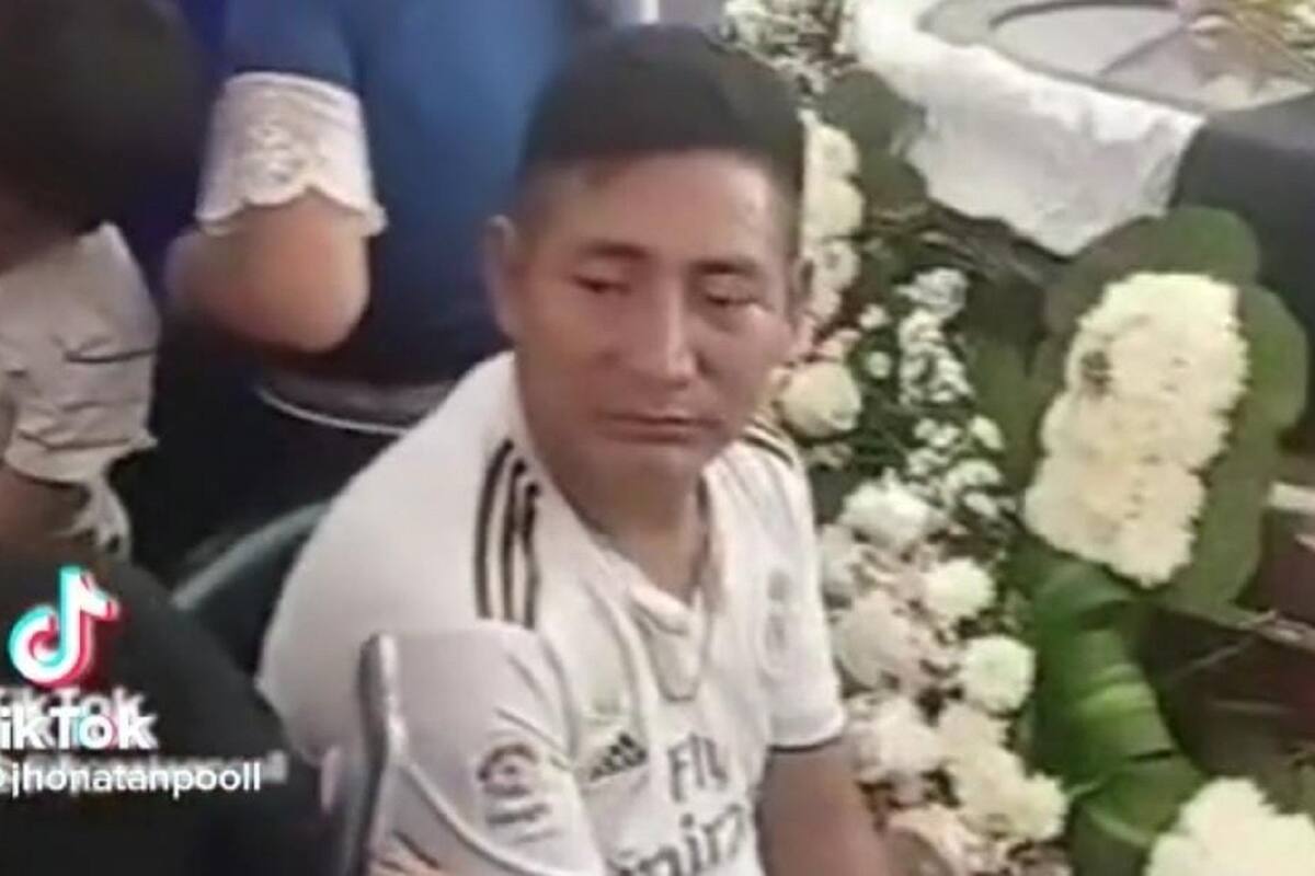 Hombres se ponen a ver un partido del mundial de Qatar durante un funeral