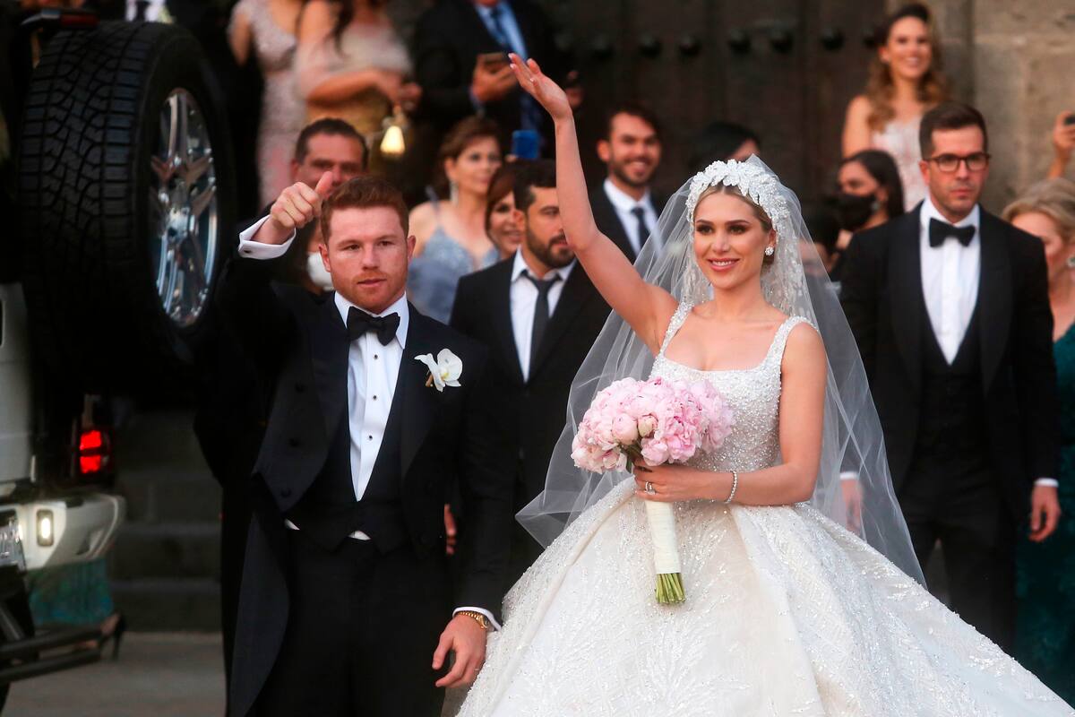 MEX2562 GUADALAJARA (MÉXICO) 22/05/2021.- El campeón mundial de peso supermedio de la Asociación Mundial de Boxeo (AMB) y del Consejo Mundial de Boxeo (CMB) Saul "Canelo" Álvarez y su esposa Fernanda Gómez, saludan hoy, al salir de su boda en la catedral de Guadalajara, estado de Jalisco (México). El mexicano Saúl "Canelo" Álvarez, mejor boxeador libra por libra a día de hoy, se casó este sábado con su pareja Fernanda Gómez en una ceremonia privada en la Catedral de Guadalajara, occidente de México. EFE/Francisco Guasco