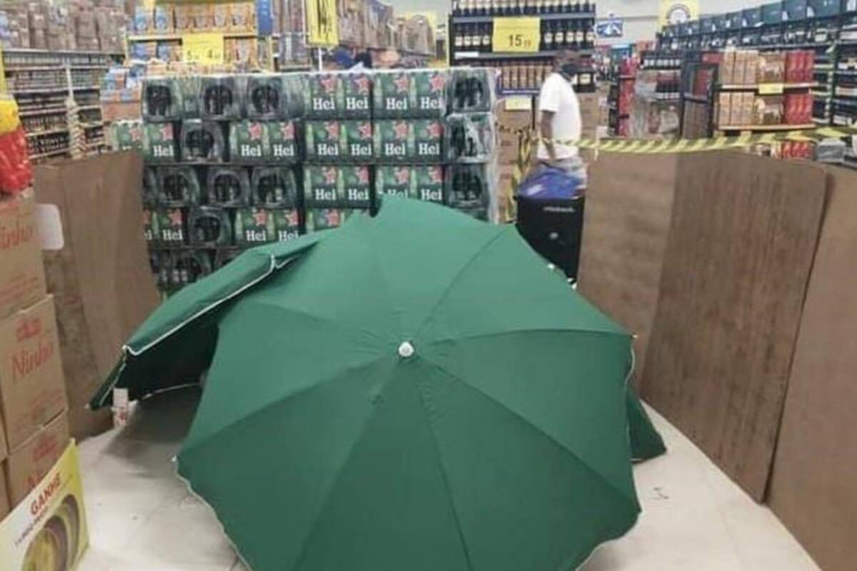 ¡Indignante! Muere trabajador de supermercado, lo cubren con paraguas y siguen trabajando