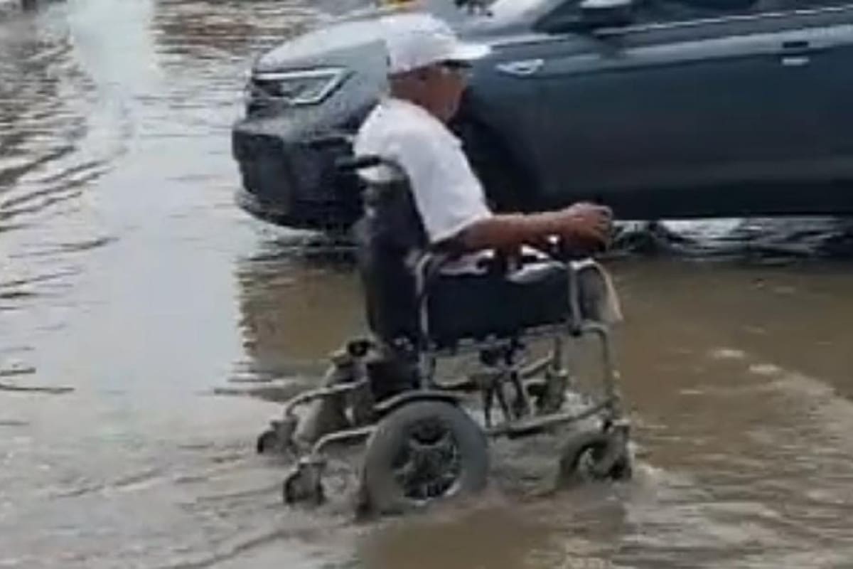 Captan a señor en silla de ruedas cruzando calle inundada a toda velocidad
