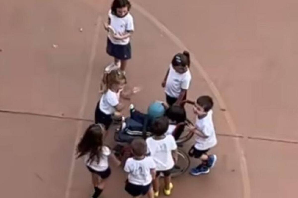 Niños ayudan a su compañero en silla de ruedas para que juegue con ellos